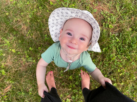 Cute Happy Baby Looks up at Mom, Tugging on her Pants