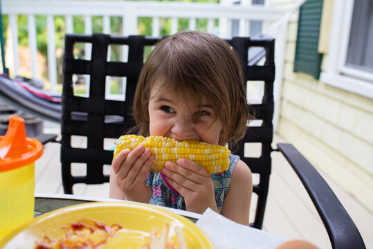 Little Girl Eats Corn on the Cob for Dinner