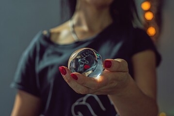 Mujer sosteniendo una bola de cristal con reflejo de corazón