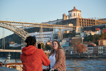 A woman taking a picture of her friend in Porto