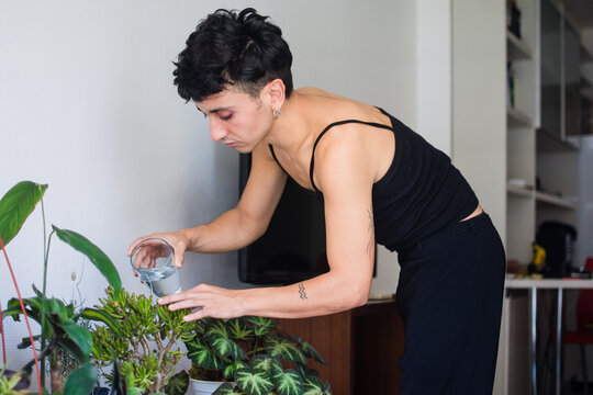 Non binary person taking care of their plants