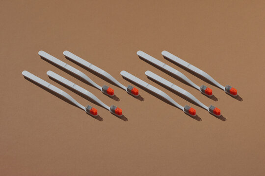 A row of wooden toothbrushes on a brown background