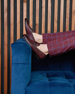 A man in blue leather monks and burgundy checkered trousers