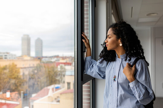 Stylish Woman Looking Out The Apartment Window