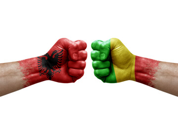 Two hands punch to each others on white background. Country flags painted fists, conflict crisis concept between albania and mali