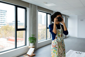 Woman taking pictures at painting studio 