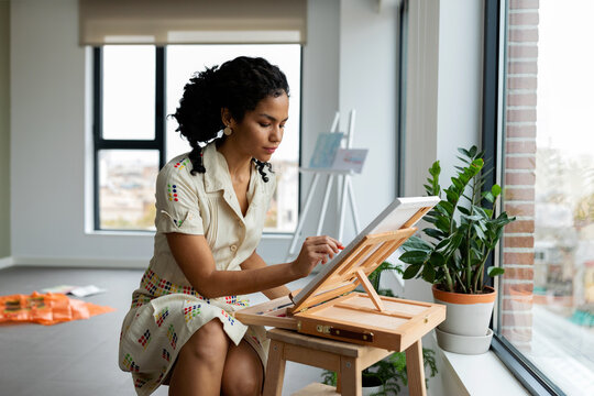 Elegant woman painting with chalk at studio