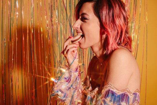 Woman eating macaroon during party
