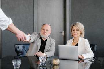 Crop worker serving businesspeople in office