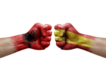 Two hands punch to each others on white background. Country flags painted fists, conflict crisis concept between albania and spain