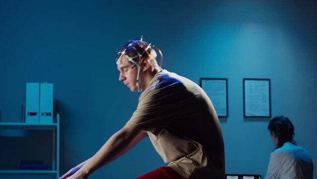 EEG topographer for examining brain, doctor making electrogram of scalp activity. Researching of brain work, man riding bicycle in electroencephalography headset. Rehabilitation after damage in sport.