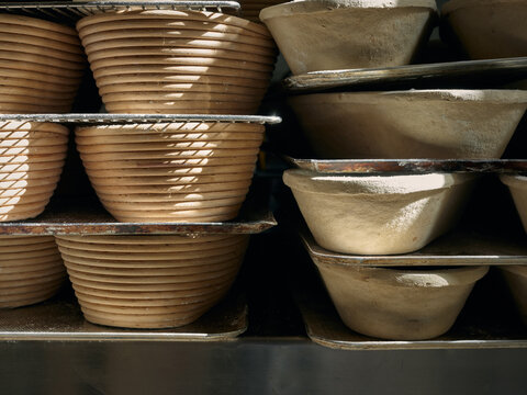 Stacks of empty baskets for proofing in a bakery corner.