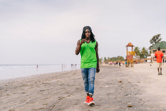 Black man strolling on seashore
