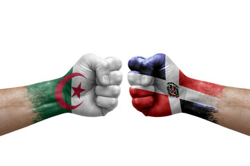 Two hands punch to each others on white background. Country flags painted fists, conflict crisis concept between algeria and dominican republic