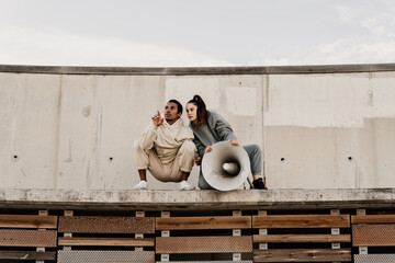 Woman talking on megaphone on top of wall