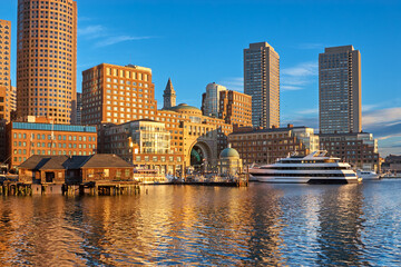 Obraz premium Downtown Boston waterfront around Rowes Wharf lit up by morning sun on a clear Summer day