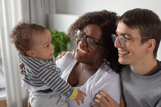 family couple with newborn baby, smiling portrait