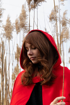 Pretty girl in red holding dune grass 