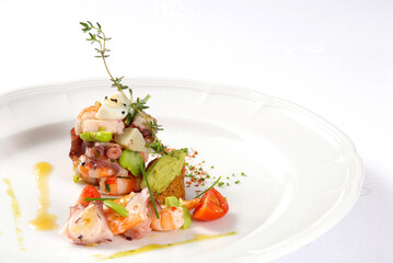 Shrimp and octopus, plate of shrimp, scallops, octopus, avocado, tomato, bread and olive oil on white background with space for tex
