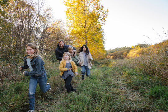 Family Walking Together In Grass