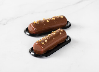 Vegan dessert. Chocolate nut mousse cake in the shape of a candy bar with mirror glaze on a light background. Close-up