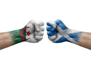 Two hands punch to each others on white background. Country flags painted fists, conflict crisis concept between algeria and scotland
