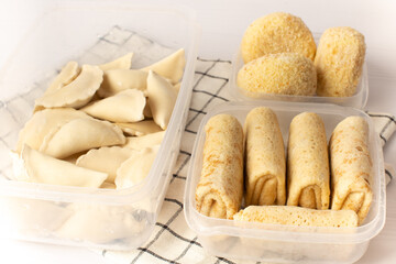 Frozen semi-finished products in containers on a white table