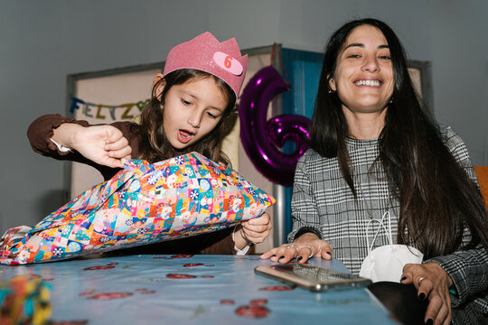 Birthday Girl Opening Gift Near Mom