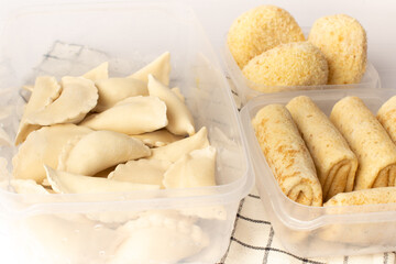 Frozen semi-finished products in containers on a white table