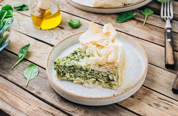 Vegetarian spinach pie with feta cheese on white wooden background. Traditional Greek spinach pie...