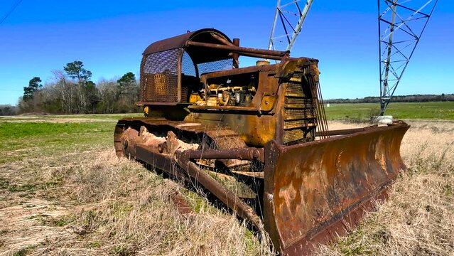 Corner distant pan Old antique rusted vintage abandoned tractor on a farm inoperable