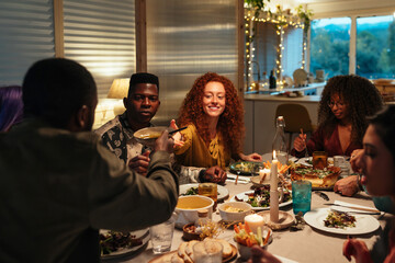 Multiracial friends sharing food during dinner
