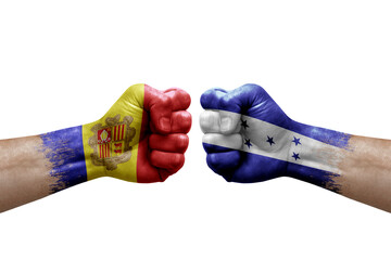 Two hands punch to each others on white background. Country flags painted fists, conflict crisis concept between andorra and honduras