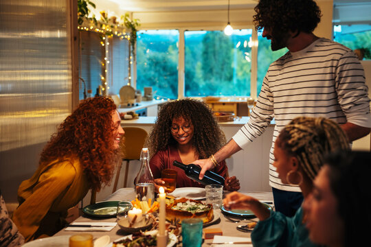 Man pouring wine for women