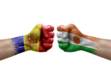 Two hands punch to each others on white background. Country flags painted fists, conflict crisis concept between andorra and niger