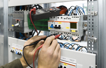 electrician measuring voltage with a digital multimeter