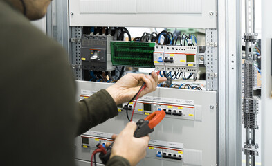 electrician measuring voltage with a digital multimeter