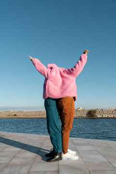 Friends sharing colorful jacket while dancing 