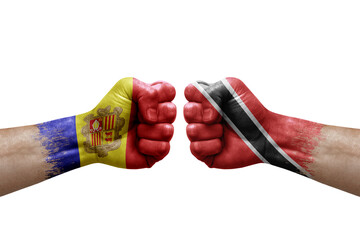 Two hands punch to each others on white background. Country flags painted fists, conflict crisis concept between andorra and tobago