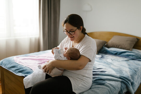 Smiling mom spending time with baby at home