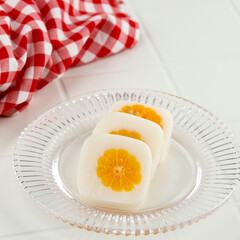 Milk Pudding with Fresh Orange at the Center, on White Table