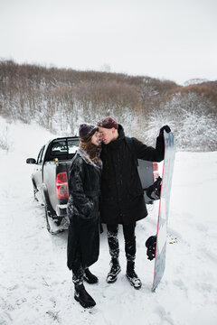 Happy couple with a snowboard in the winter