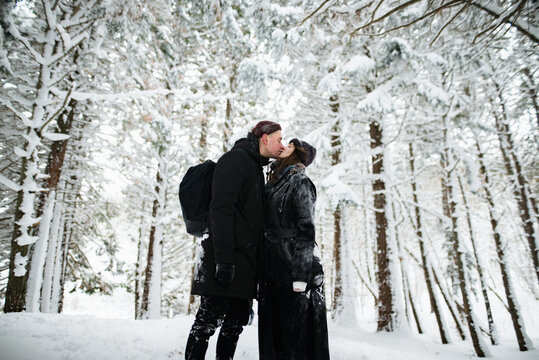 Young couple kissing in the snowy forest