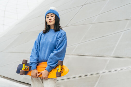 Woman holding a skateboard