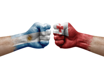 Fototapeta premium Two hands punch to each others on white background. Country flags painted fists, conflict crisis concept between argentina and tonga