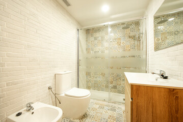 Fototapeta na wymiar Toilet tiled with hydraulic tiles on one wall and floors and another with similar white brick