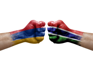 Two hands punch to each others on white background. Country flags painted fists, conflict crisis concept between armenia and gambia