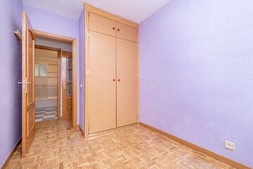 Empty room with lavender painted walls and built in wardrobe with light wood doors and french oak parquet floor