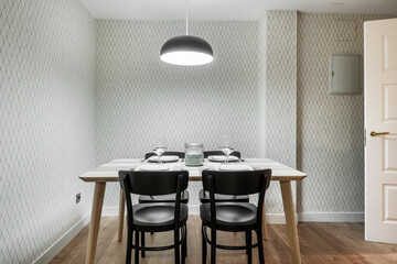 Kitchen table with food service set, black armchairs and matching lamp