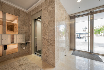Portal of an urban residential building with beige marble tiles